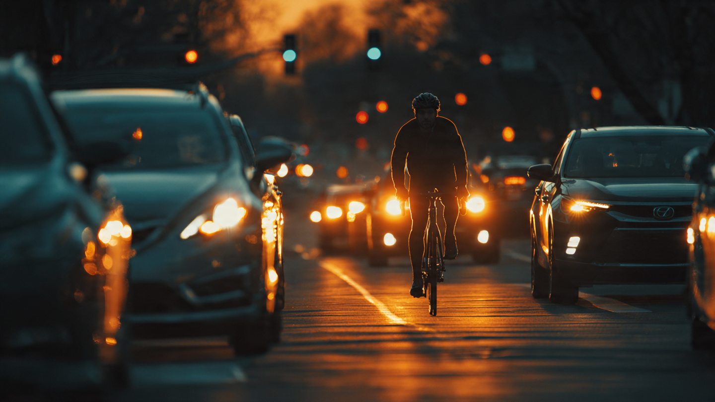 A ghostly bicycle outline passing through an AEB sensor beam that only detects a pedestrian silhouette